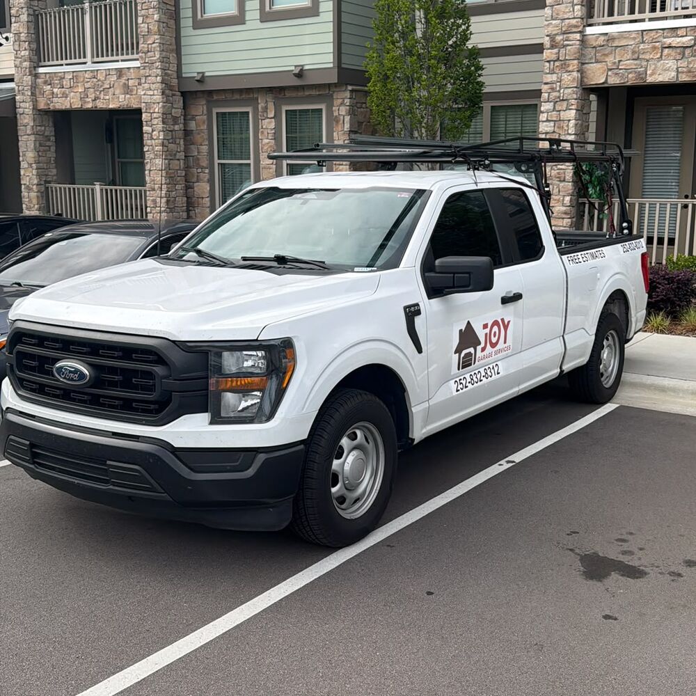 Joy Garage Services work truck with the phone number 252-832-8312 and Free Estimates on the side