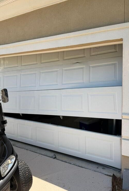 A garage door with panels out of alignment and a gap along the bottom