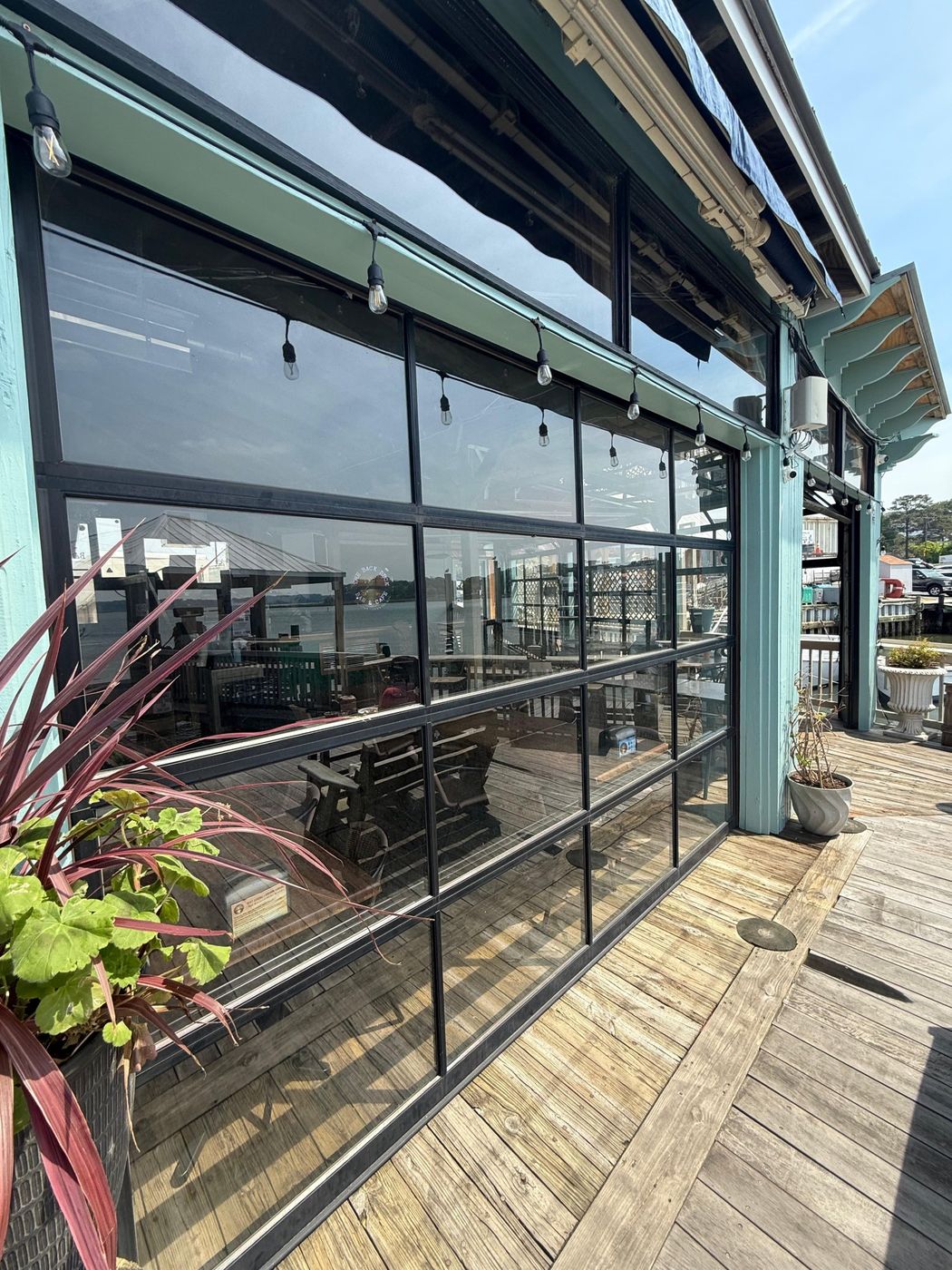 Full-view glass garage door with a black frame on a waterfront building